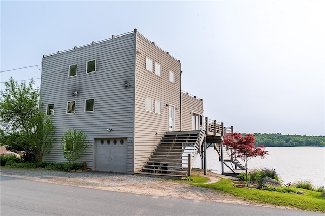 13 W Shore Rd, Kauneonga Lake, NY 12749 - view of home's exterior featuring stairway, a garage, and a water view