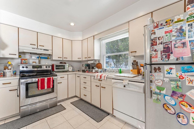 17 Linn Pl, Yonkers, NY 10705 - kitchen with appliances with stainless steel finishes, under cabinet range hood, light countertops, light tile patterned floors, and recessed lighting