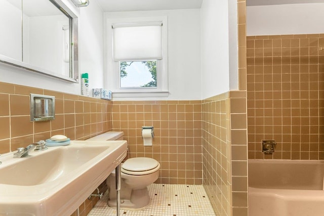 17 Linn Pl, Yonkers, NY 10705 - bathroom with toilet, tile walls, tile patterned flooring, a sink, and wainscoting