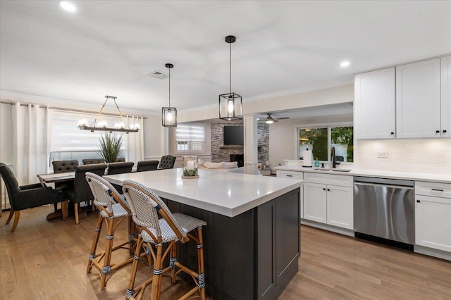 105 Shoreham Way, Merrick, NY 11566 - kitchen with stainless steel dishwasher, ceiling fan, white cabinetry, wood finished floors, and a sink