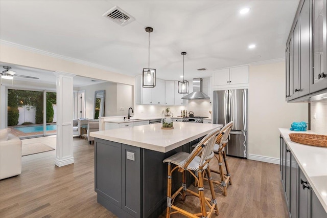105 Shoreham Way, Merrick, NY 11566 - kitchen featuring freestanding refrigerator, wall chimney exhaust hood, light countertops, a sink, and open floor plan