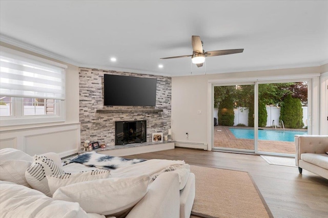 105 Shoreham Way, Merrick, NY 11566 - living area with a baseboard heating unit, plenty of natural light, ceiling fan, crown molding, and wood finished floors