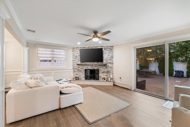 105 Shoreham Way, Merrick, NY 11566 - living room with a baseboard radiator, crown molding, wood finished floors, ceiling fan, and a large fireplace
