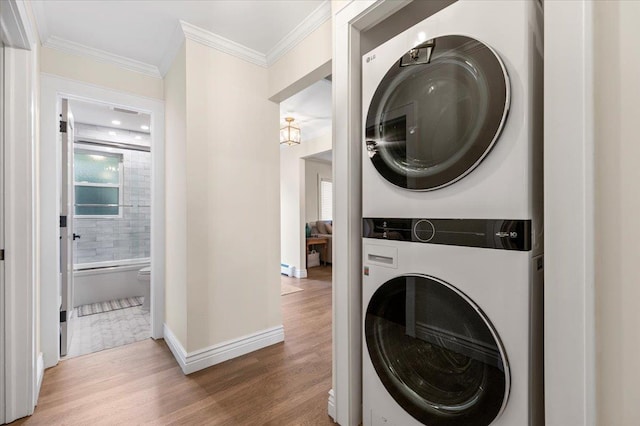 105 Shoreham Way, Merrick, NY 11566 - laundry room with stacked washing machine and dryer, wood finished floors, ornamental molding, and baseboards