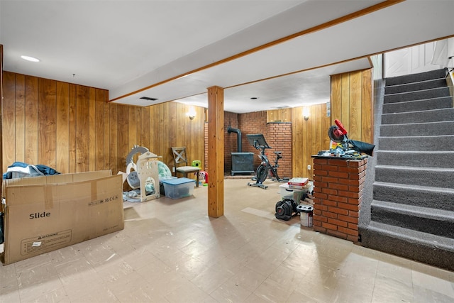 69 Wickham Dr, Warwick, NY 10990 - finished below grade area featuring a wood stove, stairs, wooden walls, and tile patterned floors