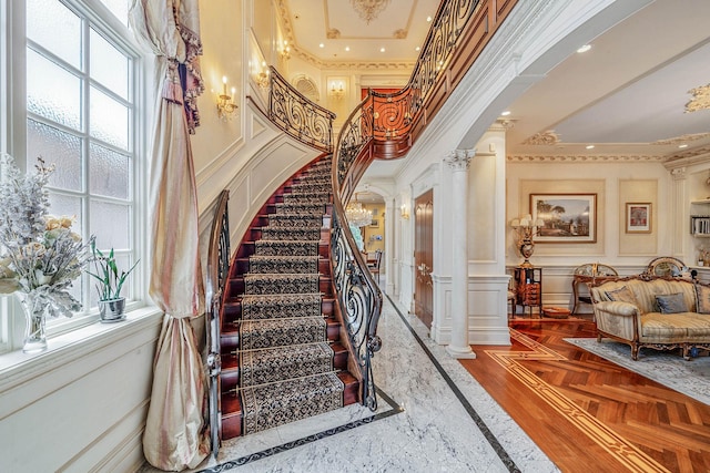 16136 90th St, Howard Beach, NY 11414 - stairway featuring a decorative wall, crown molding, ornate columns, inlaid floor details, and arched walkways