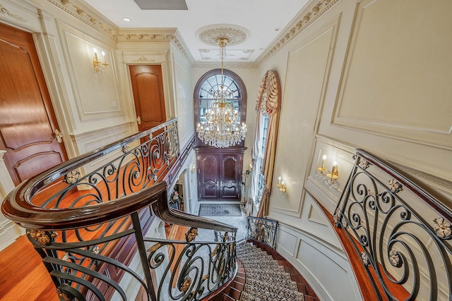 16136 90th St, Howard Beach, NY 11414 - staircase featuring a chandelier, a decorative wall, and crown molding