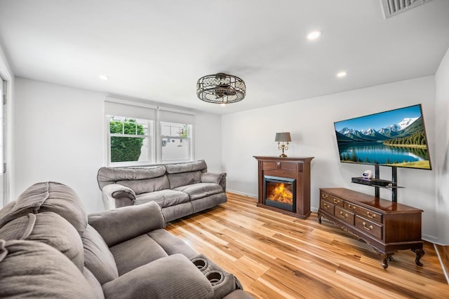220 Farhan Ln, North Babylon, NY 11703 - living area with wood finished floors, recessed lighting, a glass covered fireplace, and baseboards