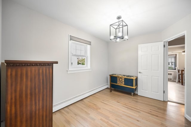 220 Farhan Ln, North Babylon, NY 11703 - unfurnished dining area featuring a baseboard heating unit, light wood-type flooring, a chandelier, and baseboards