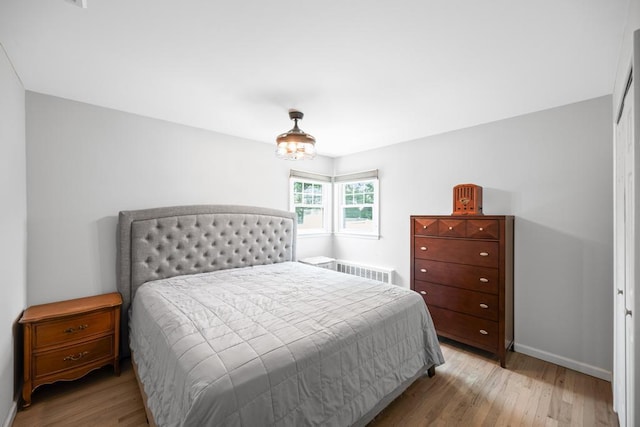 220 Farhan Ln, North Babylon, NY 11703 - bedroom with light wood finished floors, baseboards, and radiator heating unit