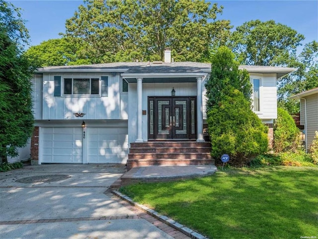 446 Joan Ct, West Hempstead, NY 11552 - view of front of property featuring french doors, a front lawn, an attached garage, concrete driveway, and a chimney