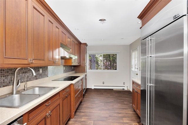 446 Joan Ct, West Hempstead, NY 11552 - kitchen featuring appliances with stainless steel finishes, a baseboard radiator, brown cabinetry, dark wood-style floors, and tasteful backsplash