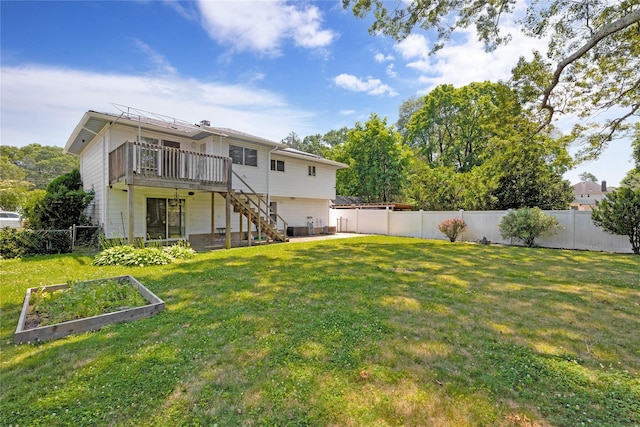 446 Joan Ct, West Hempstead, NY 11552 - back of property with a garden, a fenced backyard, stairway, and a wooden deck