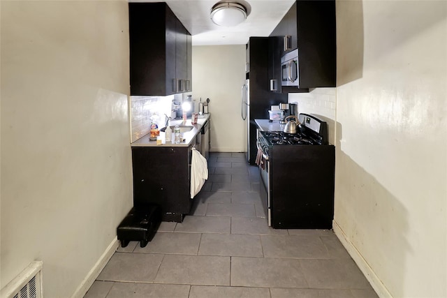 2105 Wallace Ave Unit 4A, Bronx, NY 10462 - kitchen featuring stainless steel appliances, dark cabinetry, backsplash, and light tile patterned flooring
