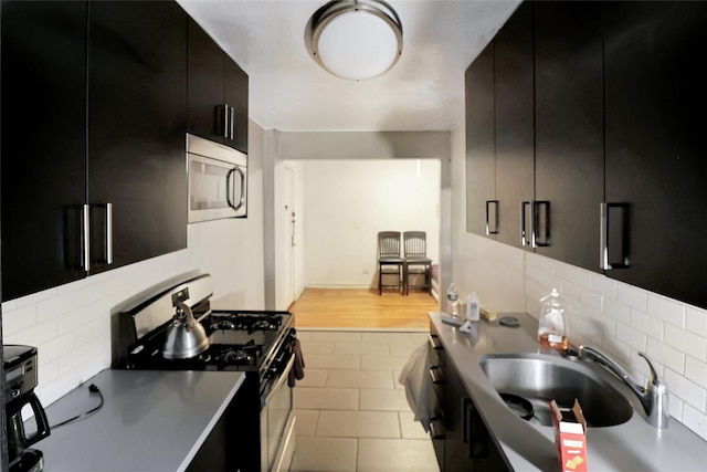 2105 Wallace Ave Unit 4A, Bronx, NY 10462 - kitchen with dark cabinets, appliances with stainless steel finishes, backsplash, modern cabinets, and light tile patterned floors