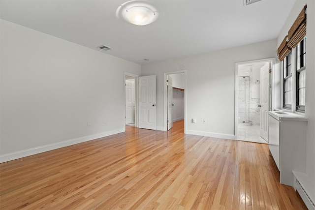 341 Furnace Dock Rd Unit 30, Cortlandt Manor, NY 10567 - unfurnished bedroom with a baseboard heating unit, light wood-style flooring, a walk in closet, and ensuite bath