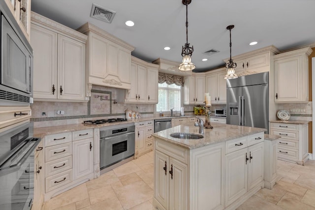 251 Wilmot Dr, Hewlett, NY 11557 - kitchen featuring appliances with stainless steel finishes, a sink, tasteful backsplash, light stone counters, and a center island with sink