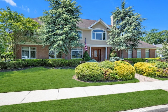 251 Wilmot Dr, Hewlett, NY 11557 - view of front of home with a front yard, brick siding, and a chimney