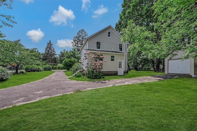 506 Raynor Ave, Riverhead, NY 11901 - view of property exterior featuring driveway, a yard, a garage, and an outdoor structure