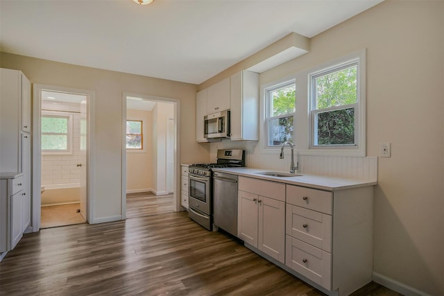 506 Raynor Ave, Riverhead, NY 11901 - kitchen with appliances with stainless steel finishes, a sink, baseboards, dark wood finished floors, and light countertops