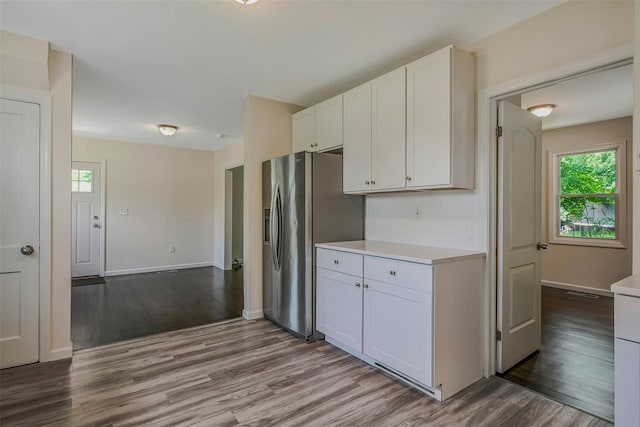 506 Raynor Ave, Riverhead, NY 11901 - kitchen featuring dark wood finished floors, stainless steel refrigerator with ice dispenser, white cabinetry, light countertops, and baseboards