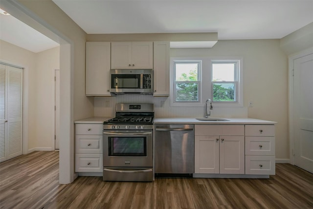 506 Raynor Ave, Riverhead, NY 11901 - kitchen with appliances with stainless steel finishes, a sink, dark wood-style flooring, and light countertops