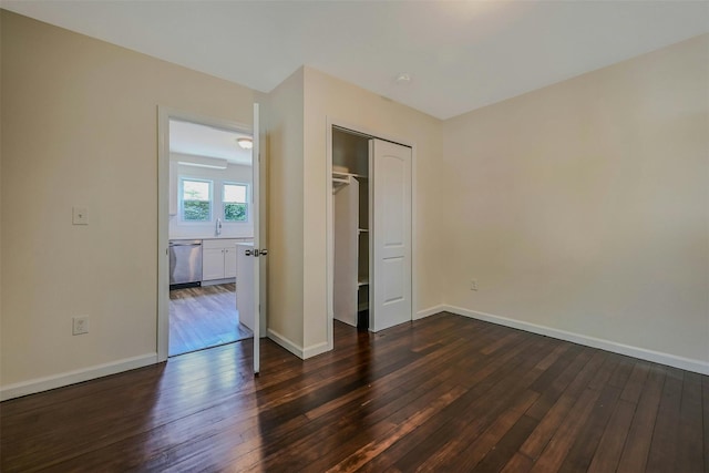 506 Raynor Ave, Riverhead, NY 11901 - unfurnished bedroom with dark wood-style flooring, baseboards, a closet, and a sink
