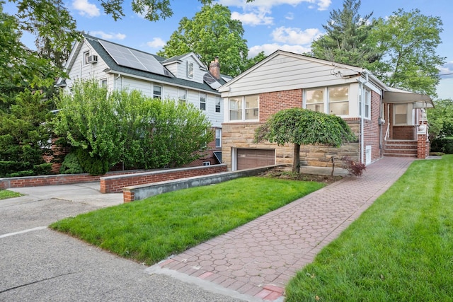 8043 Utopia Pkwy, Jamaica Estates, NY 11432 - bungalow-style house featuring brick siding, a front yard, an attached garage, and stone siding