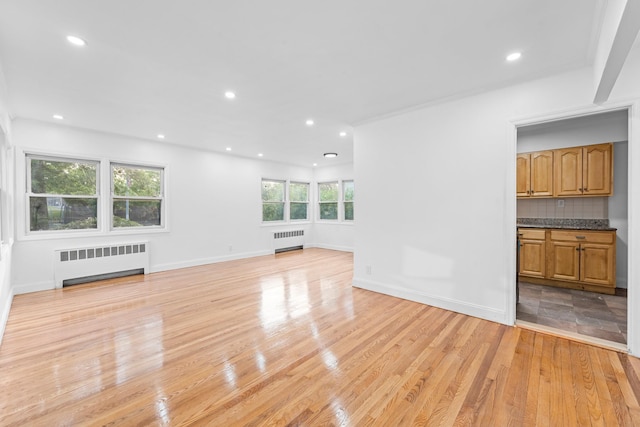 8043 Utopia Pkwy, Jamaica Estates, NY 11432 - unfurnished living room featuring radiator, light wood-type flooring, recessed lighting, and baseboards