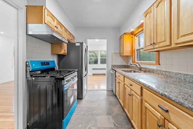 8043 Utopia Pkwy, Jamaica Estates, NY 11432 - kitchen featuring appliances with stainless steel finishes, radiator heating unit, under cabinet range hood, a sink, and stone countertops