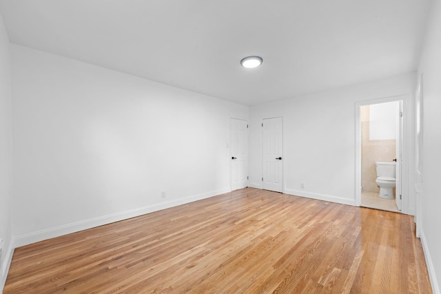 8043 Utopia Pkwy, Jamaica Estates, NY 11432 - unfurnished bedroom with light wood-style floors, baseboards, and ensuite bathroom
