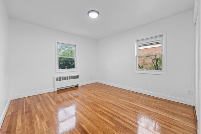 8043 Utopia Pkwy, Jamaica Estates, NY 11432 - spare room featuring radiator, light wood-style flooring, and baseboards