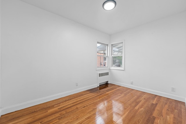 8043 Utopia Pkwy, Jamaica Estates, NY 11432 - spare room with radiator, wood finished floors, and baseboards