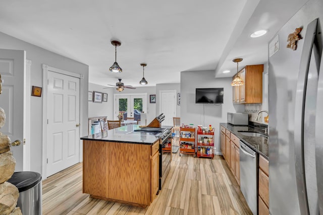 65 Oxford Springs Rd, Chester, NY 10918 - kitchen with appliances with stainless steel finishes, a center island, light wood-type flooring, ceiling fan, and dark stone countertops
