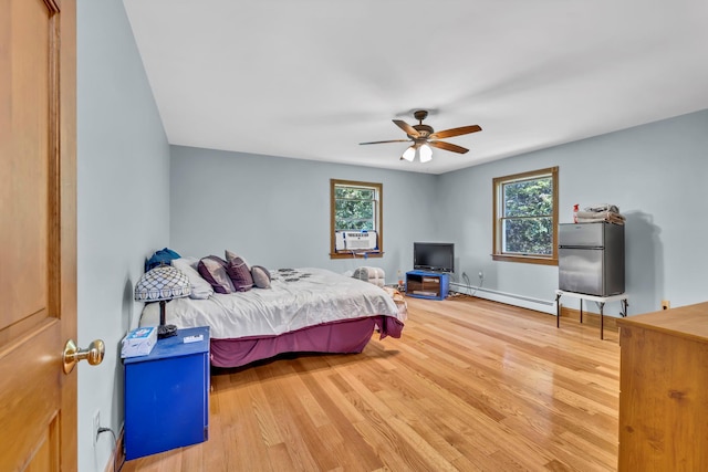 65 Oxford Springs Rd, Chester, NY 10918 - bedroom with a baseboard heating unit, wood finished floors, freestanding refrigerator, a ceiling fan, and cooling unit
