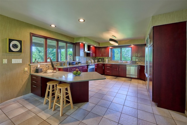 99 Dietz Rd, Jeffersonville, NY 12748 - kitchen with appliances with stainless steel finishes, wall chimney range hood, a peninsula, backsplash, and light countertops