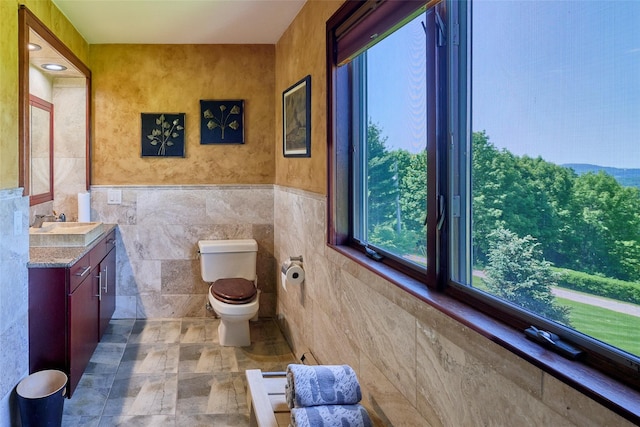 99 Dietz Rd, Jeffersonville, NY 12748 - bathroom featuring vanity, tile walls, stone finish floors, and wainscoting