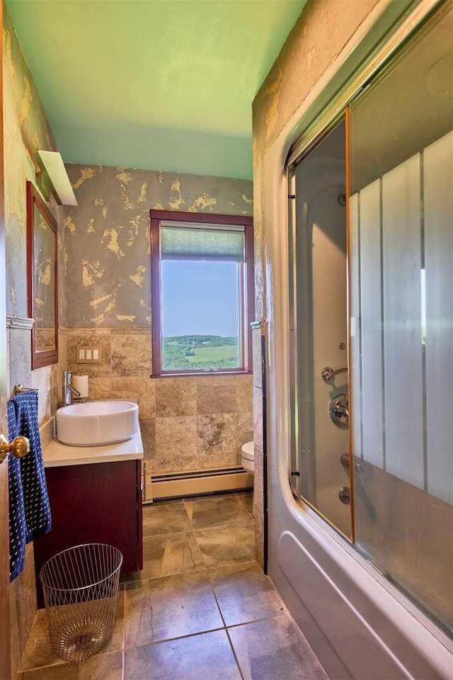 99 Dietz Rd, Jeffersonville, NY 12748 - full bath featuring baseboard heating, vanity, wainscoting, wallpapered walls, and shower / bath combination with glass door