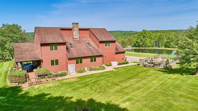 99 Dietz Rd, Jeffersonville, NY 12748 - back of house featuring a water view, a chimney, a lawn, a shingled roof, and a view of trees