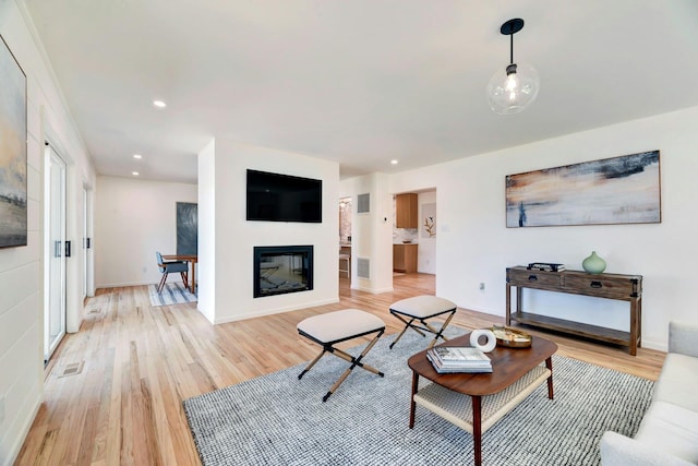 2000 Beebe Dr, Cutchogue, NY 11935 - living room featuring light wood finished floors, recessed lighting, and a glass covered fireplace