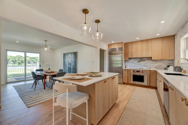 2000 Beebe Dr, Cutchogue, NY 11935 - kitchen with light brown cabinets, appliances with stainless steel finishes, modern cabinets, light wood-type flooring, and recessed lighting