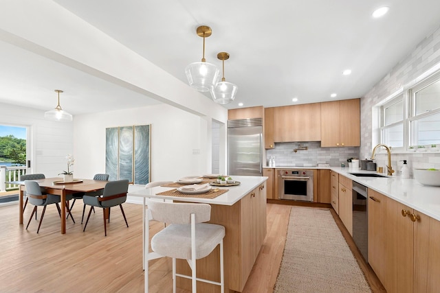 2000 Beebe Dr, Cutchogue, NY 11935 - kitchen with decorative backsplash, light countertops, light wood-style flooring, appliances with stainless steel finishes, and modern cabinets