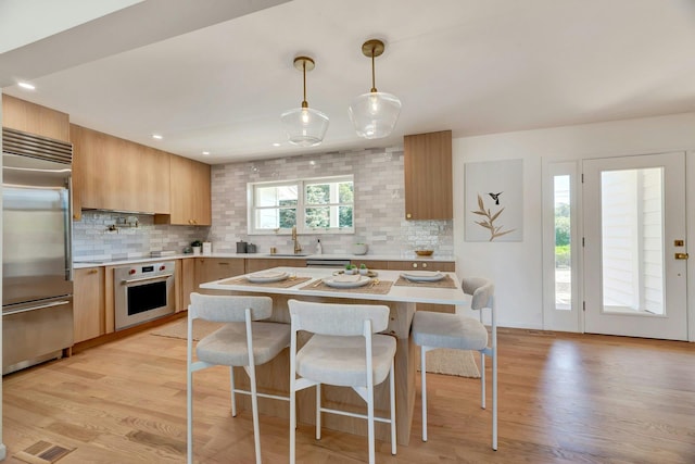 2000 Beebe Dr, Cutchogue, NY 11935 - kitchen featuring stainless steel appliances, light countertops, tasteful backsplash, a breakfast bar area, and recessed lighting