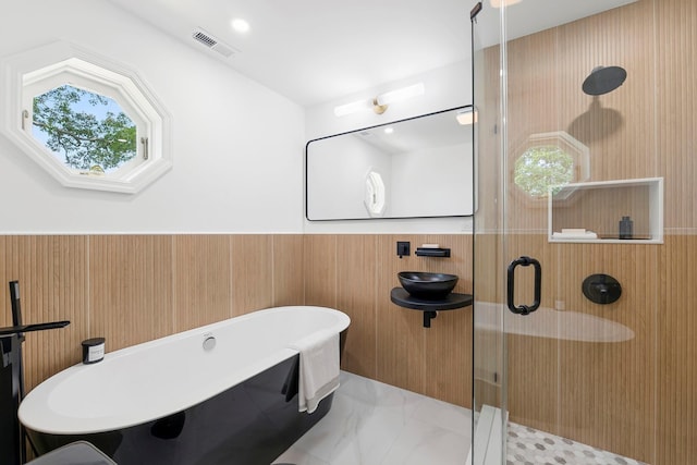 2000 Beebe Dr, Cutchogue, NY 11935 - full bathroom with a freestanding tub, a shower stall, marble look tiles, and wainscoting