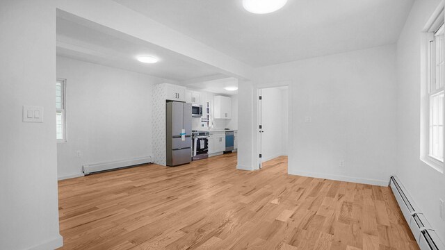 2227 Boller Ave, Bronx, NY 10475 - unfurnished living room with a baseboard heating unit, baseboard heating, light wood-style flooring, and healthy amount of natural light