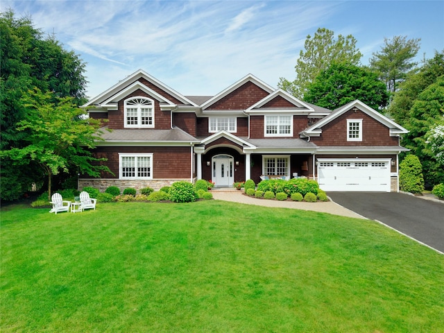 15 Elm Ln, Manhasset, NY 11030 - view of front facade with driveway, a front lawn, a garage, and stone siding