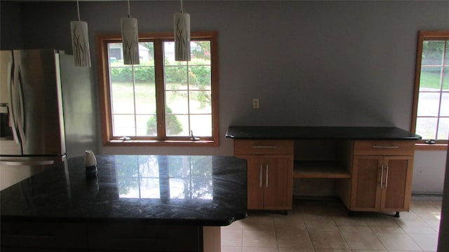 231 Lakeview Rd, Wappingers Falls, NY 12590 - kitchen with stainless steel fridge, dark countertops, light tile patterned floors, and brown cabinets