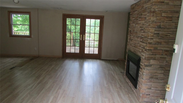 231 Lakeview Rd, Wappingers Falls, NY 12590 - unfurnished living room with healthy amount of natural light, light wood-style flooring, a fireplace, and french doors
