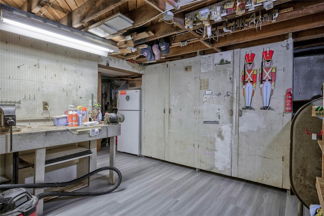 30 W 12th St, Huntington Station, NY 11746 - unfinished below grade area featuring freestanding refrigerator, a workshop area, and wood finished floors