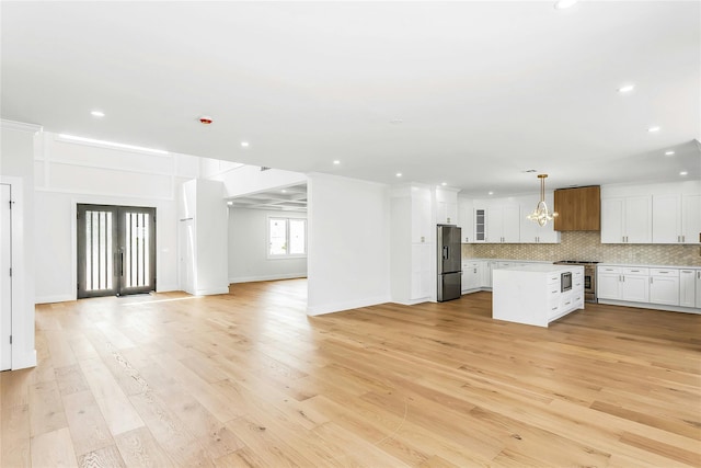9 Vista Ln, Levittown, NY 11756 - unfurnished living room featuring light wood finished floors, recessed lighting, a chandelier, and baseboards